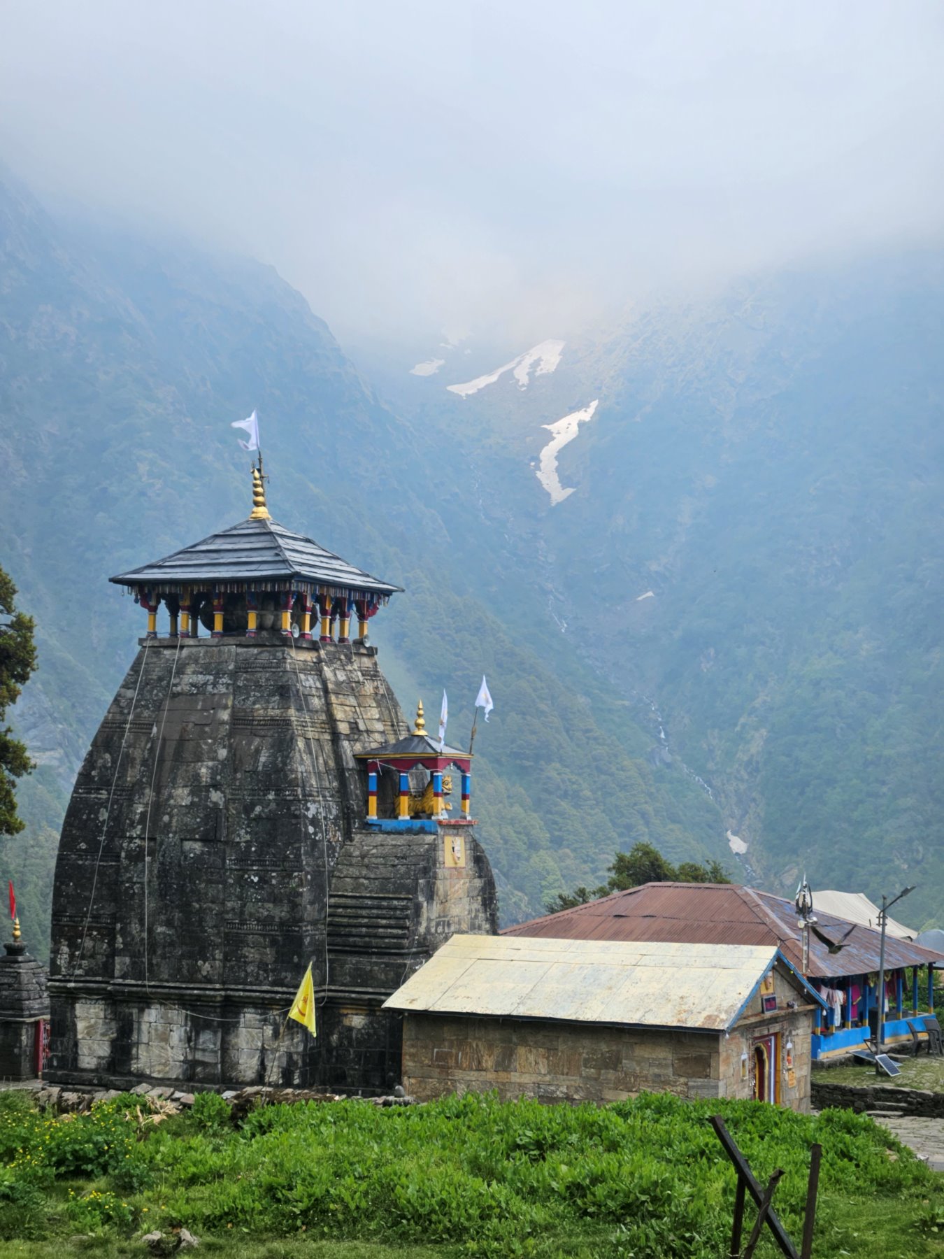 The stone shikhara of Tungnath temple against a misted Himalayan valley
