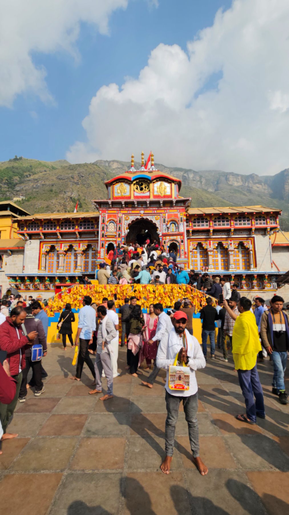 The painted facade of Badrinath temple, pilgrims gathered on the steps