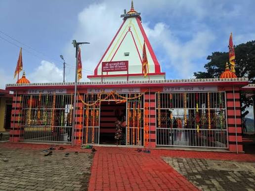 Kunjapuri Temple, its red-and-white spire set against the sky