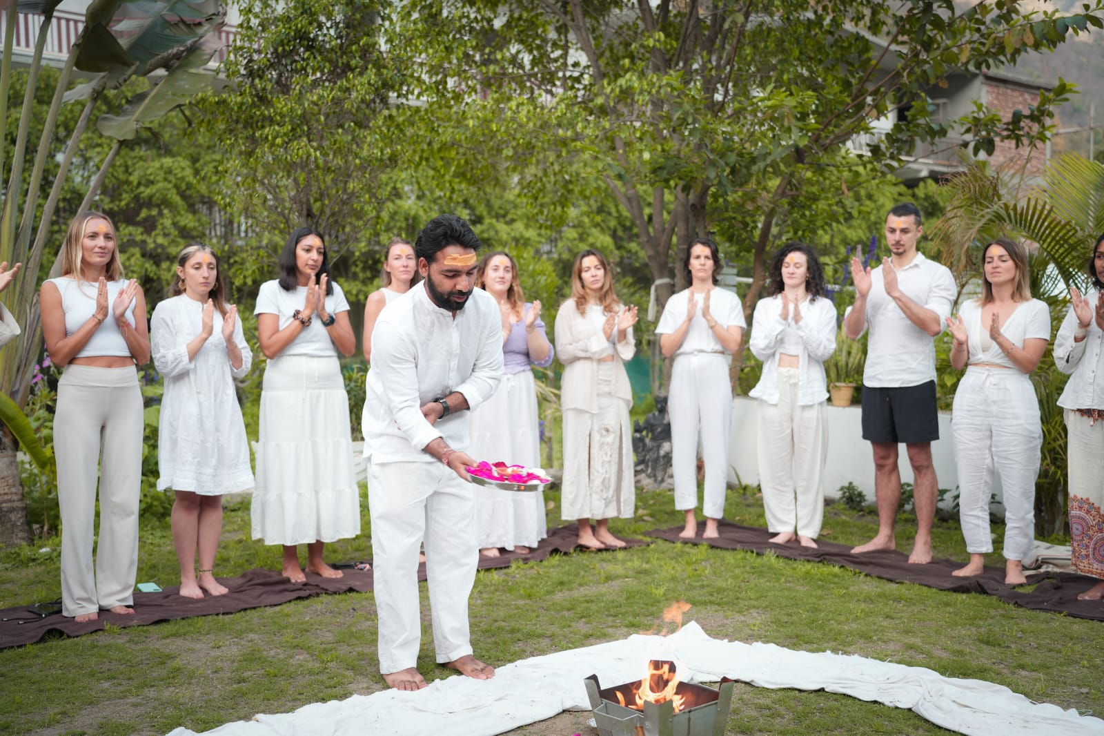 Pradeep Ramola leading a fire ceremony, guests in white gathered around him