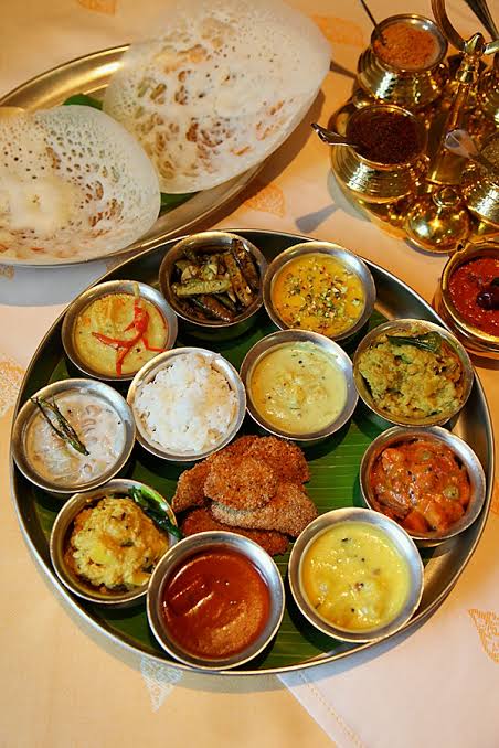 A sattvic thali with dosa and a variety of small vegetarian dishes